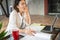 Asian sleepy young woman working with papers and laptop