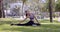 Asian slim woman stretching neck and legs sitting in park