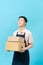 Asian smart handsome male cafe and bakery business owner, holding boxes for delivery bread to customers