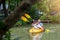 Asian son and father are rowing a yellow kayak