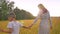 Asian son and his pretty mother walking along on yellow field tenderly holding their hands