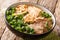 Asian soup made of stewed or braised beef, broth, vegetables and Chinese noodles closeup in a bowl. horizontal