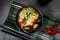 Asian soup with noodles ramen, with miso paste, soy sauce, mussels and shrimps prawn. On a dark stone table, with