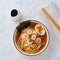 Asian soup with noodles, ramen with shrimps. White stone table, top view