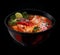 asian spicy soup with lime in a black and red plate