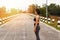 Asian sport woman in sportwear standing on road. Fitness woman resting after workout session