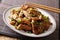 Asian stir-fried beef in teriyaki sauce with sesame and green on