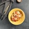 Asian Stir Fried Shrimp and Rice Noodles. Sesame Rice Noodles with Shrimp in yellow plate with wooden chopstick on dark slate