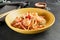 Asian Stir Fried Shrimp and Rice Noodles. Sesame Rice Noodles with Shrimp in yellow plate with wooden chopstick on dark slate