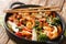 Asian stir fried shrimp, squid and mussels with fresh seasonal vegetables close-up in a pan. horizontal