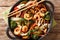 Asian stir fried shrimp, squid and mussels with fresh seasonal vegetables close-up in a pan. horizontal top view