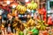 Asian street agricultural markets abound with different sorts of ripe fresh fruits. Bunches of yellow bananas hang at shopboard