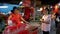 Asian street food market. Girl buys roasted chestnuts