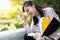 Asian student child girl hold book in her hand,rubbing her eye feeling eyes fatigue,stressed schoolgirl suffer eyestrain,massaging