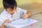 Asian student drawing and painting colours on the paper in the room. Studyâ€‹ fromâ€‹ home, socialâ€‹ Distancing, Kid and educatio