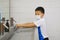 Asian student kid wearing medical face mask washing hands by himself on sink  in the basin, bathroom sink