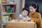 Asian student in preschool use a letter box make a study word in class room with his teacher