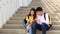 Asian Student sitting stairs at outdoor place. Couple people using book