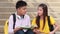 Asian Student sitting stairs at outdoor place. Couple people using book