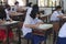 Asian students wearing surgical masks sit in the classroom for exams.