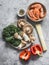 Asian style food ingredients for preparing lunch - shrimp, egg noodles, sweet pepper, kale, shiitake mushrooms on a grey
