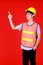 Asian supervisor foreman wearing safety suit and safety helmet standing and smile feel happy and confident pointing to copy space.