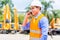 Asian supervisor telephoning on construction site