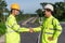 Asian survey engineers handshake on road construction site, after use theodolite mark a expressway at highway success, Civil