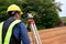 Asian surveyor engineer checking level of soil with Surveyor\'s Telescope equipment to measure leveling for cut and fill