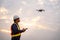 Asian surveyors or explorer use drones to view construction sites or check security at sunset