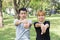 Asian sweet couple warm up their bodies by stretching arms before morning jogging exercise in the park.