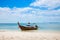 Asian taxi. Long-tailed boat on a tropical white sand beach. Blue sky and sea, mountains on the horizon. It is cloudy