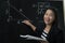 Asian teacher explane mathematics formula to her student in classroom