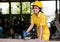 Asian technician girl with yellow suit and helmet is working with shot machine