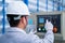 Asian technician worker wearing a safety suit and setting Shearing Machine in industrial factory, Safety first concept