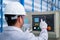 Asian technician worker wearing a safety suit and setting Shearing Machine in industrial factory, Safety first concept