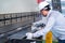 Asian technician worker wearing a safety suit and sheet Metal Bending in industrial factory, Safety first concept