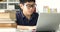 Asian teen boy waring eyeglass and used laptop computer at home, cute boy doing your homework with serious face.