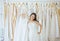 Asian teen bride trying on wedding dress,Woman designer making adjustment in wedding dress shop