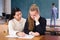 Asian teen girl explaining study material to female classmate