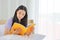 Asian teen girl student reading book on the bed for study at home as a result of new normal social distancing