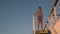 Asian teen standing on top of blue stair with yellow stripe