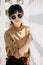 Asian teen waring round sunglasses in vintage style dress summer fashion collection model portrait