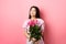 Asian teenage girl in cute dress looking romantic at empty space logo, holding valentines day flowers gift, receive