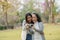 Asian teenage mother and daughter walking in park with camera to capture memories