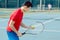 Asian tennis player looking at the ball with concentration before serving