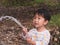 Asian Thai cute kid holding water hose