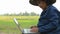Asian Thai farmer using laptop computer in the rice field