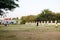 Asian thai father training and playing football or soccer with son at playground on yard in public garden park in Thailand