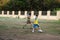 Asian thai father training and playing football or soccer with son at playground on yard in public garden park in Thailand